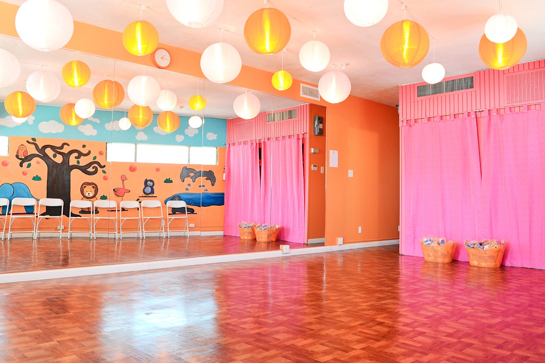 A bright yoga studio with pink curtains and paper lanterns.